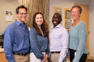 Alpine Surgical team indoors – Group of five smiling staff members inside clinic