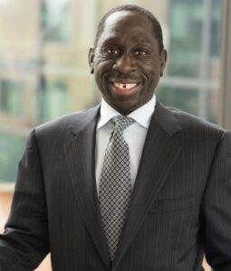 Oral surgeon in Boulder, CO – Professional headshot of male doctor in dark business suit smiling