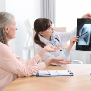 Medical consultation with digital x-ray – Patient and provider discussing scan results on tablet