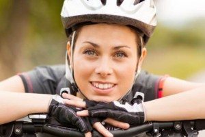 Close-up of a female cyclist in helmet smiling confidently